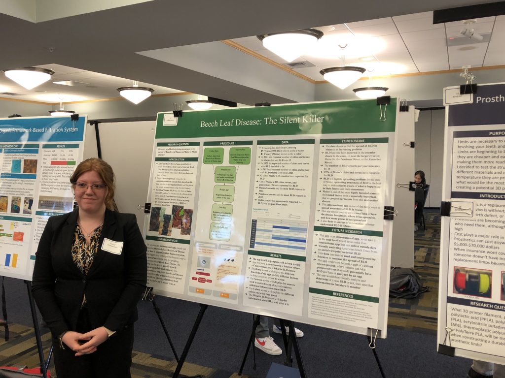 A photo of a student with their poster