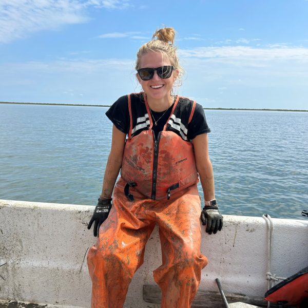 Dr. Alex Schneider sitting on the edge of a boat
