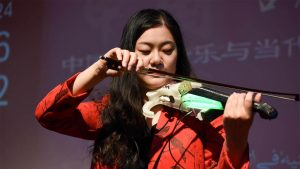 A photo of Ruixin Niu playing a 3D printed violin