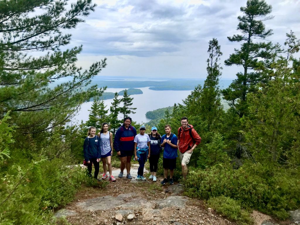 Group photo taken outdoors on a hiking trail