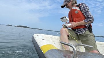 Woman operates drone from boat
