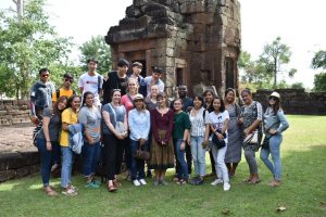 A group of students standing in front of ruins of a temple in Thailand.