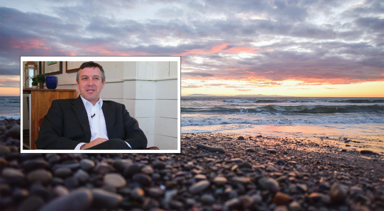 A sunset photo of a rocky coastline with a photo of Colin Woodard inset within.