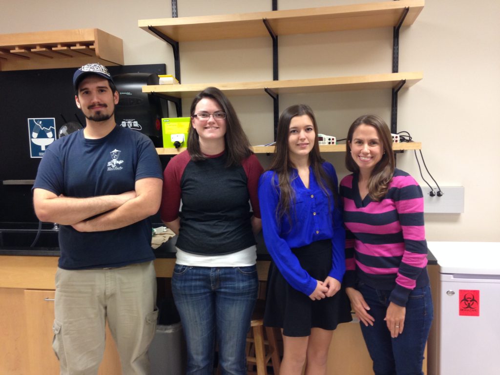 Dr. Maginnis and 3 lab members stand in the lab