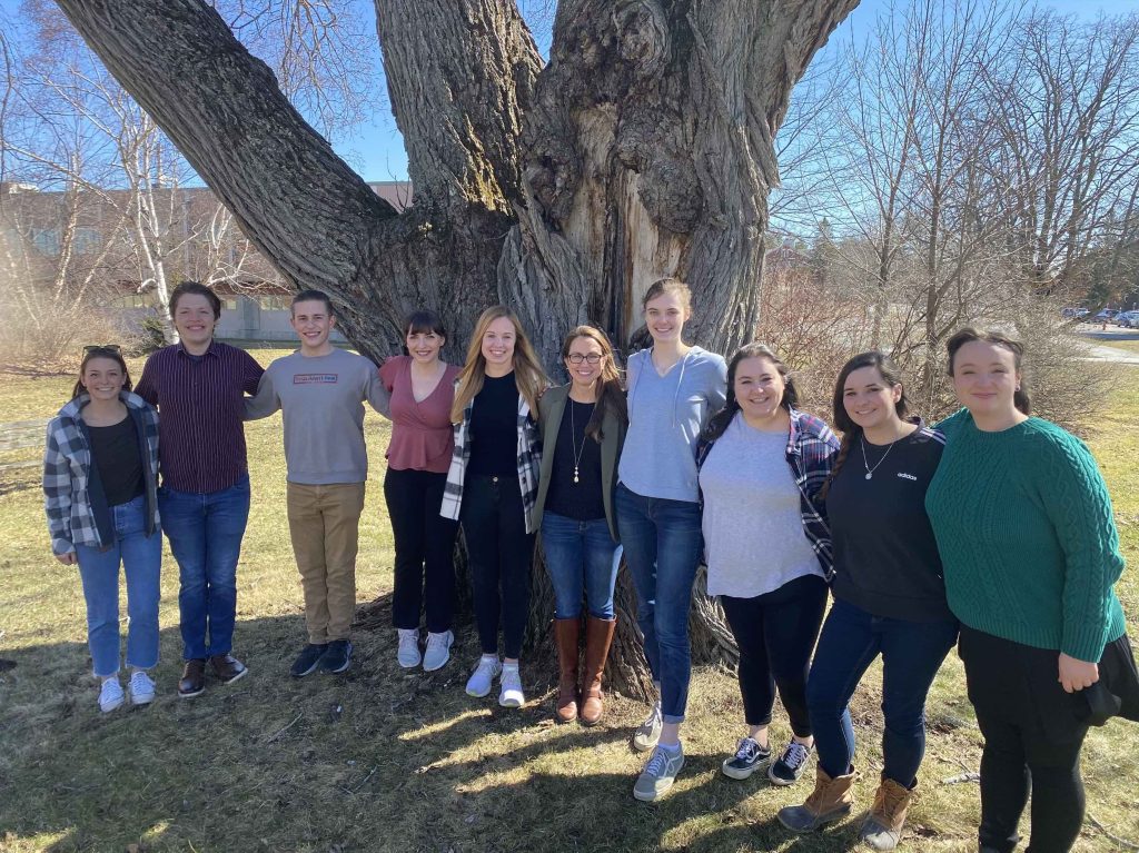 Dr. Maginnis and 9 members stand outside at UMaine