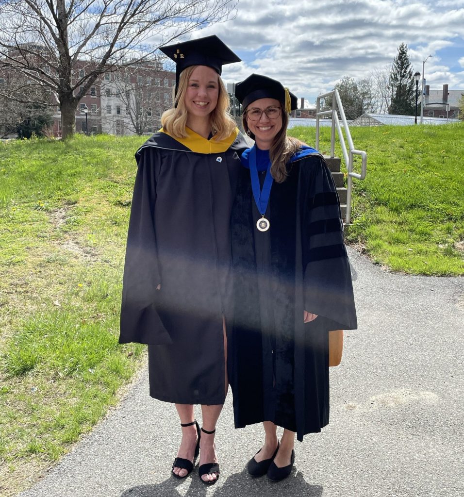 Dr. Maginnis and Amanda Sandberg stand outside at UMaine in graduation regalia