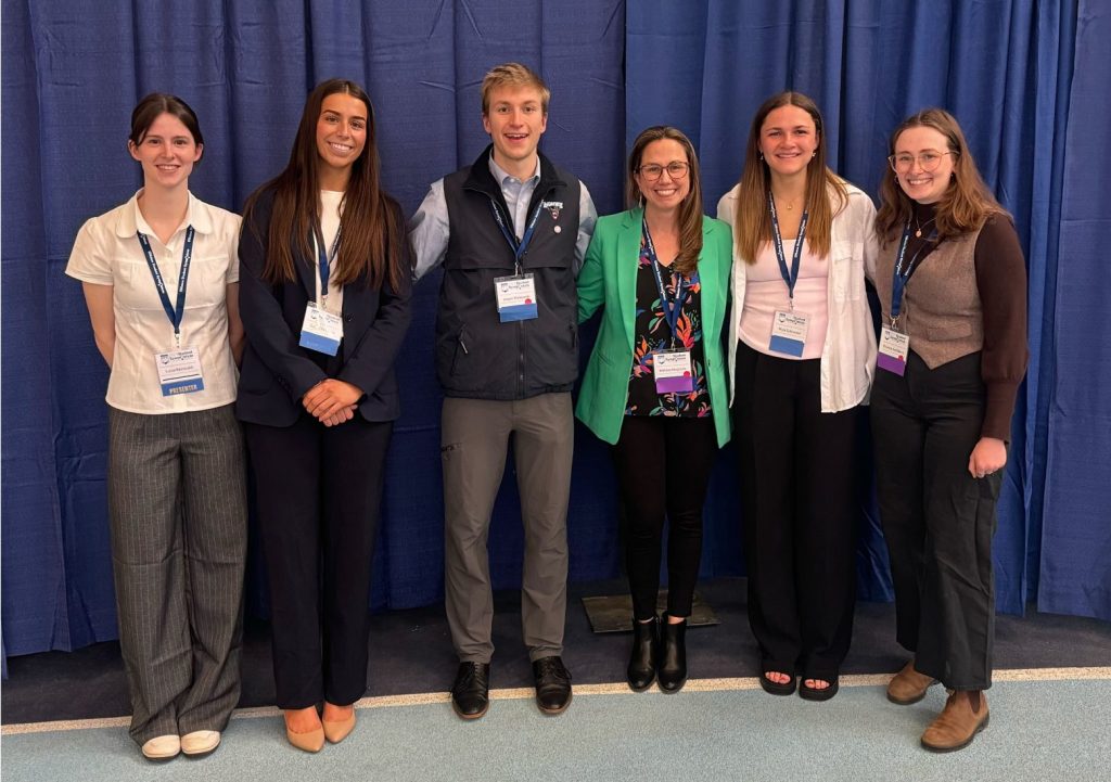 5 lab members stand with Dr. Melissa Maginnis