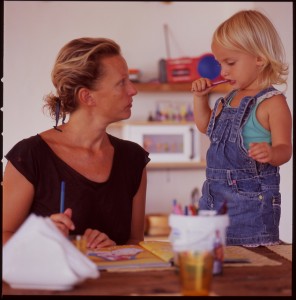 mother and young child coloring at table