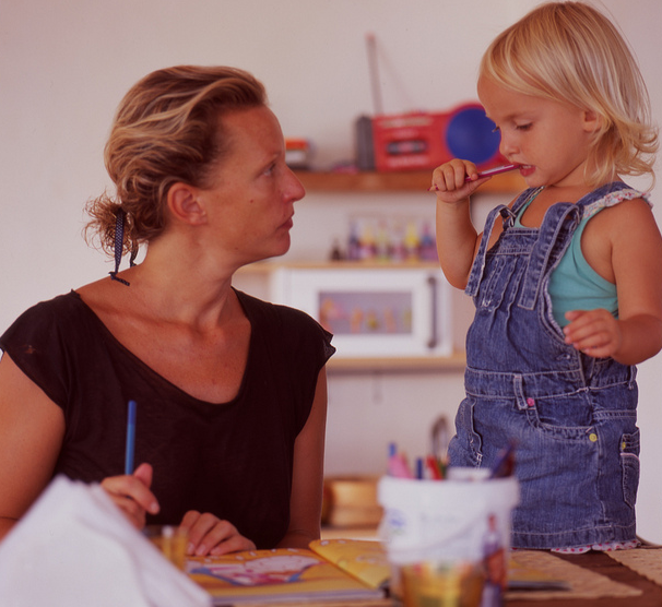 Mother and young child reading book at table