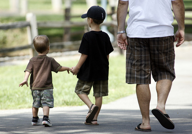 Two young boys walking with Dad