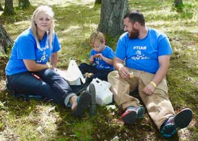 Mom, Dad and son picnicing in the grass