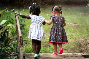 Two young girls walking in grass