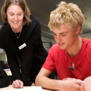 teacher and teen boy at desk