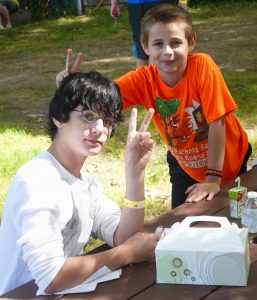 Two boys outdoors signing 'Peace' sign
