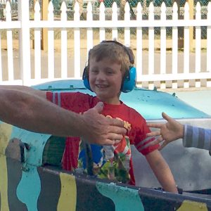 Boy with headphones riding amusement ride