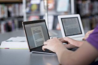 hands typing at laptop