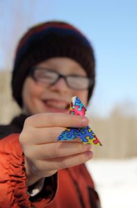 Boy holding up autism puzzle ribbon