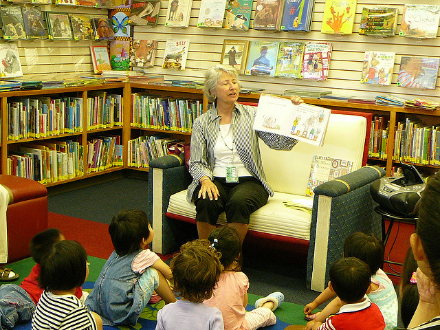 Librarian reading a picture book to group of small children