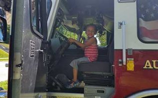 Young boy sitting in firetruck