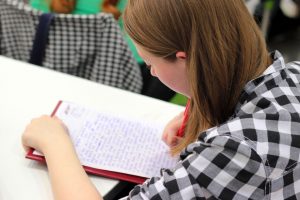 young woman taking notes in classroom