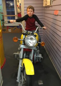 Young boy smiling sitting on motorcycle