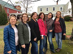 Six women posed together and smiling