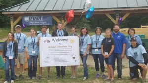 Group of volunteers standing with welcome sign