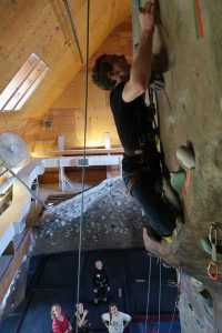Young man climbing indoor rock wall
