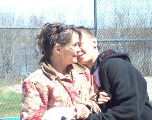 Teen son hugging his mom