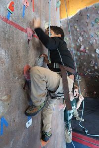 Young boy climbing indoor rock wall