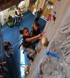 Young girl climbing indoor rock wall