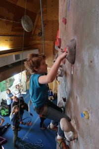 Young boy climbing indoor rock wall