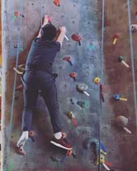 Teen climbing indoor rock wall