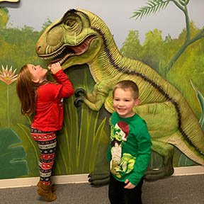 Young boy and girl at Museum with dinosaur
