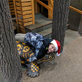 Young boy at Museum, laying atop large ceramic turtle