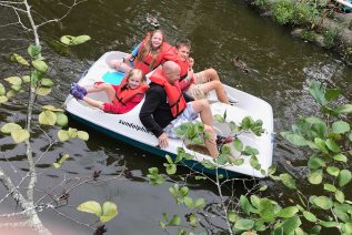 Family in a paddle boat on water