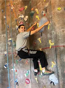 Teen boy smiling from an indoor climbing wall