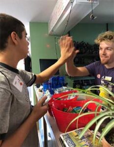 teen boy hi-fiving a staff member