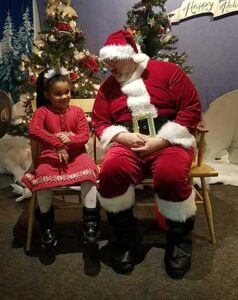 Young girl sitting next to Santa