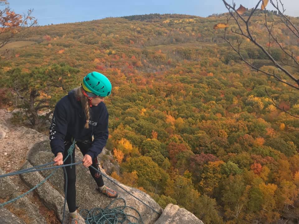 girl top belaying on a cliff