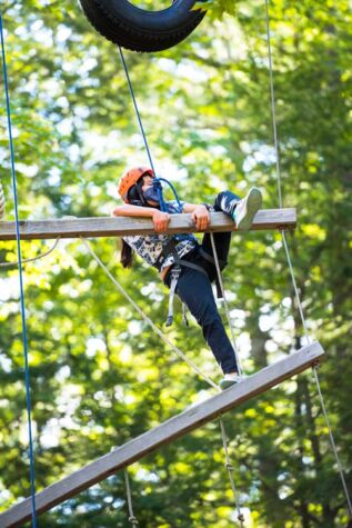 someone climbing on the high ropes course