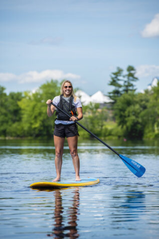 a person on yellow paddle board under a blue sunny sky