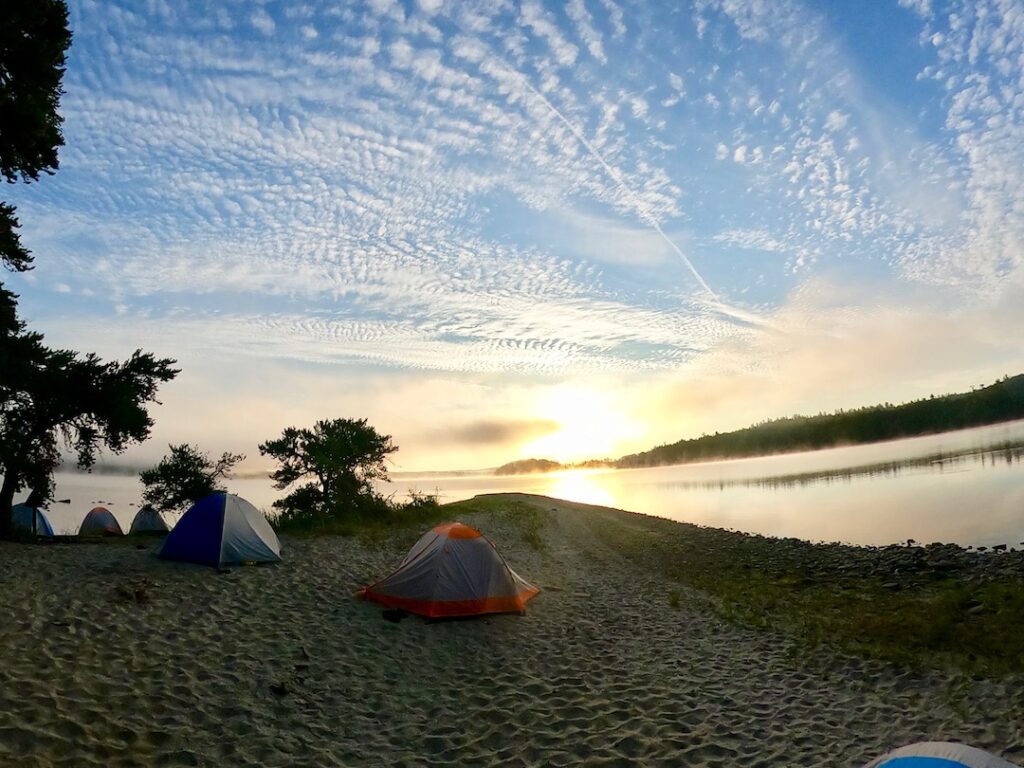 Tents on a sandy beach under a blue sky