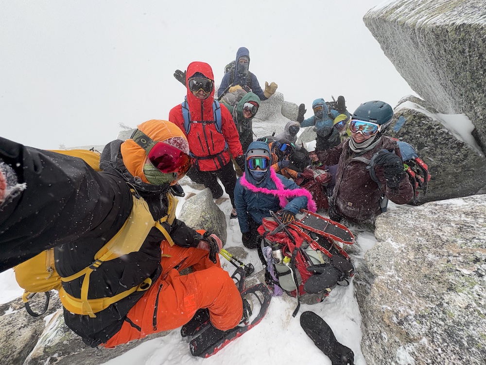 Group bundles in winter gear taking a selfie in a snow storm