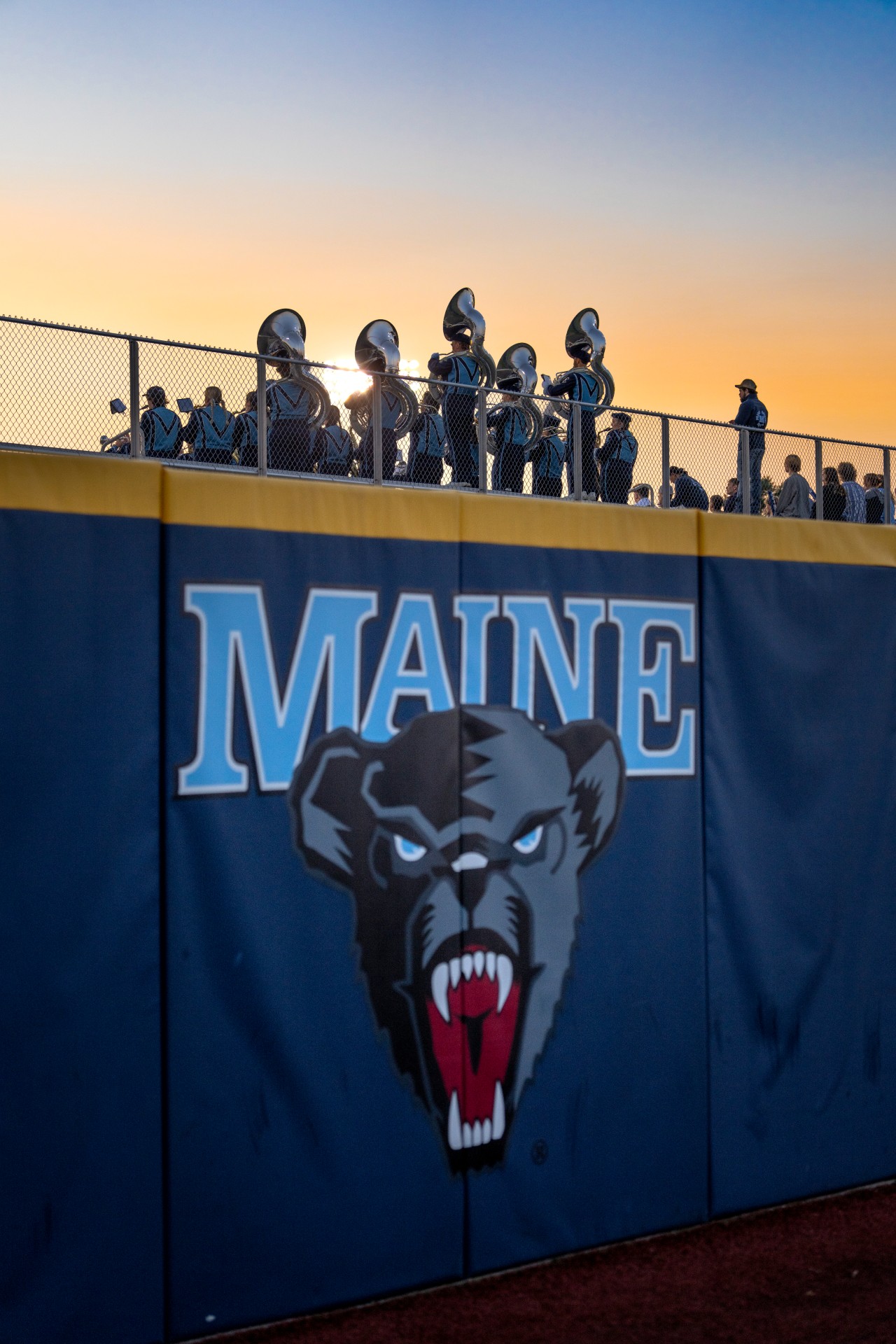 A photo of UMaine's pep band on the bleachers at sunset