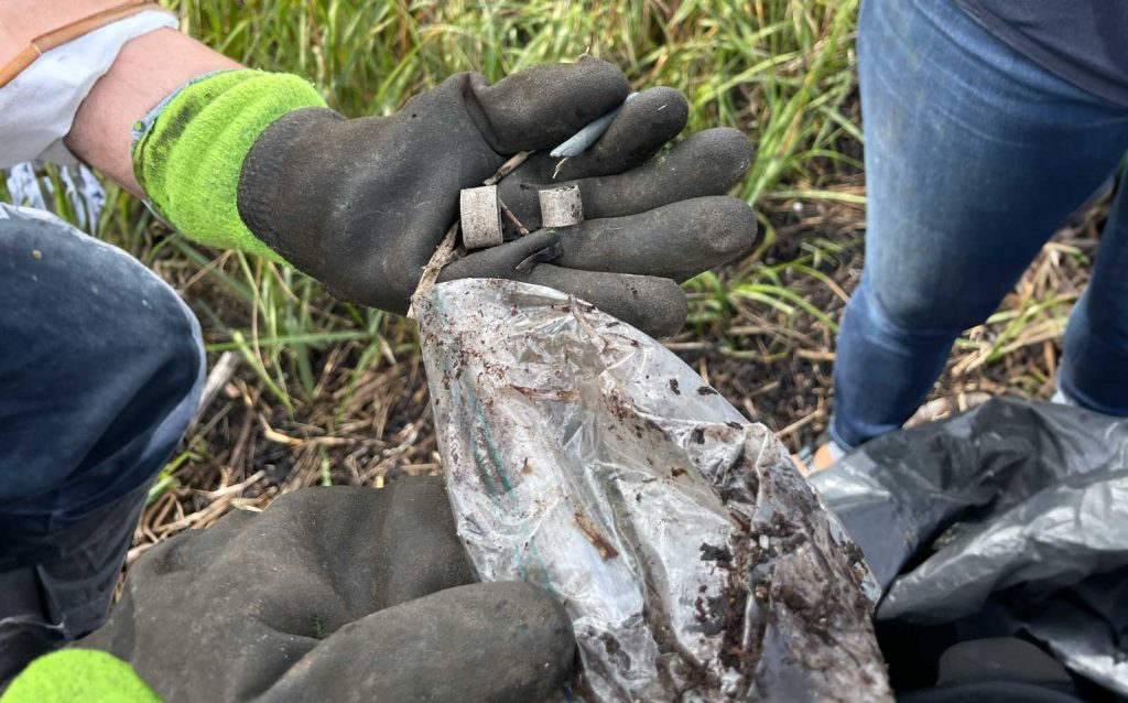 Gloved hands holding marine debris.