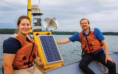 Picture of Katie Coupland and Damian Brady on a boat posting with a buoy.