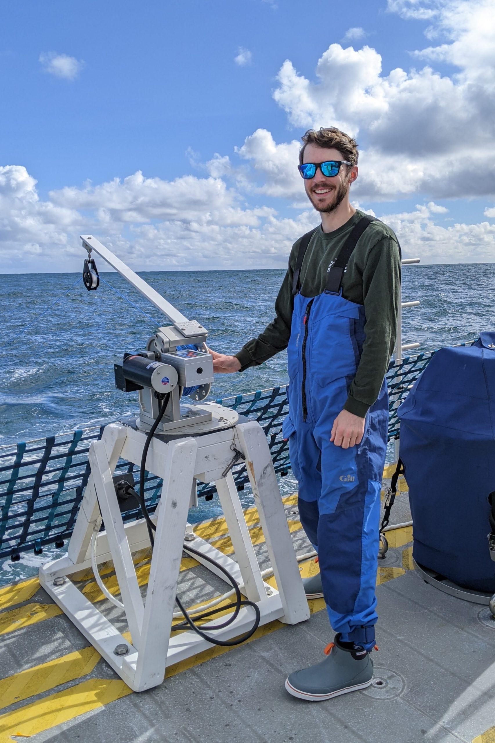 Photo of Patrick Davis performing research on a boat