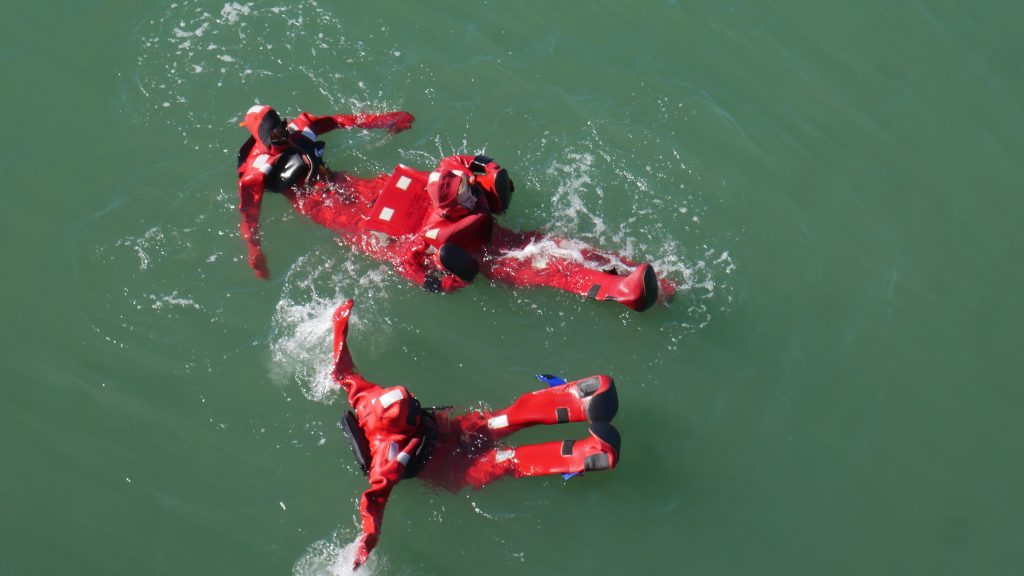 Students from the Semester by the Sea in ocean wearing survival suits.