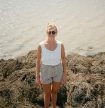 Willow Grinnell standing on seaweed covered rocks